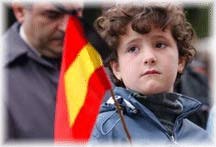Boy holds Spanish flag in mourning for those in train blast.